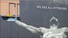  ?? MARK DUNCAN/AP FILE PHOTO ?? In this July 10, 2010, file photo, workmen remove a large mural of NBA basketball star LeBron James from a building in downtown Cleveland. For the second time in his career, James is saying goodbye to the Cleveland Cavaliers.