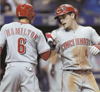  ?? AP PHOTO ?? OFFENSE COMING AROUND: Scooter Gennett (right) gets congratula­tions from Reds teammate Billy Hamilton after homering in last night’s victory against the Rays.