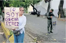  ??  ?? Una mujer sostiene un cartel en apoyo al extinto ex oficial de policía Óscar Pérez frente a un retén, cerca de la morgue en Caracas.