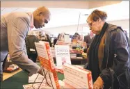  ?? Hearst Connecticu­t Media file photo ?? Dr. Ian Smith signs copies of a previous book a Danbury Barnes &amp; Noble in 2014. His latest work departs from his health-related topics. Below, the jacket of “The Ancient Nine.”