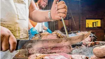  ?? Wyatt McSpadden ?? Pitmaster Roy Perez slices meat using a scimitar at Kreuz Market in Lockhart.
