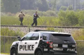  ?? Stacey Wescott / McClatchy-Tribune News Service ?? Police looking for three suspects patrol a swampy area in Fox Lake, Ill.