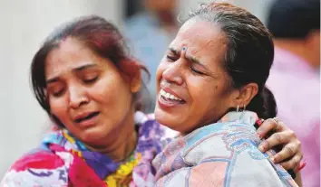  ?? Reuters ?? Women mourn the death of a relative yesterday after a commuter train travelling at high speed ■ ran through a crowd of people standing on the rail tracks on Friday in Amritsar, Punjab.