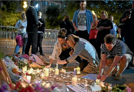  ?? PHOTO: GETTY IMAGES ?? People attend a candlelit vigil at Manchester’s Albert Square to honour the victims of the terror attack at a pop concert at Manchester Arena.