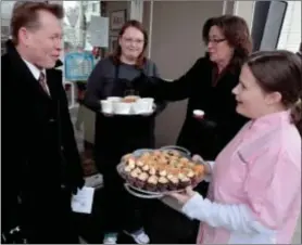  ?? Mike Mcmahon — The Record ?? Watervliet Mayor Mike Manning tries cupcakes from Amanda Stark, owner of Caroline’s Kitchen, whose baked goods will be available at Local Flavor Care.