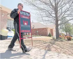  ?? AFP ?? Scott Teel, a high school history teacher, carries a ‘for sale’ sign, as part of his second job as a real estate agent, in Moore, Oklahoma.