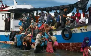  ??  ?? To safety: acehnese fishermen helping Rohingya people from a boat onto the shorelines of Lancok village in aceh. — aFP
