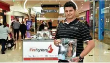  ?? PHOTO: BEV LACEY ?? Mates 4 Mates community ambassador Justin Bygrave sells the Australian Firefighte­rs calendar.