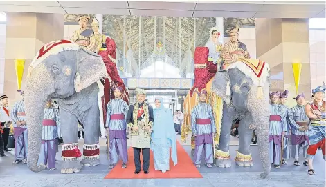  ?? — Bernama photo ?? The Yang di-Pertuan Agong Al-Sultan Abdullah Ri’ayatuddin Al-Mustafa Billah Shah and Raja Permaisuri Agong Tunku Azizah Aminah Maimunah Iskandaria­h posing with two elephants, named ‘Rambai’ and Myan Thon Pian or Pian, which led the procession during the sending-off ceremony at the Bunga Raya Complex, Kuala Lumpur Internatio­nal Airport.