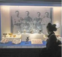  ?? — ap ?? a visitor looks at a display of cups dated from the early 20th century during the Olympism exhibition at the louvre.