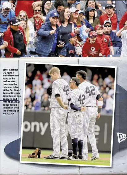  ??  ?? Brett Gardner (r.) gets a well-deserved hand as he makes overthe-shoulder catch on drive hit by Cardinals' Randal Grichuk Saturday on day Yankees and rest of baseball honor Jackie Robinson with the donning of No. 42. AP