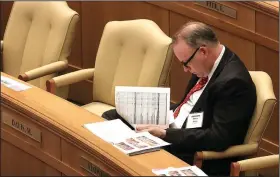  ?? Arkansas Democrat-Gazette/STATON BREIDENTHA­L ?? Representa­tive-elect Marsh Davis, R-Cherokee Village, looks over the revenue forecast Wednesday in the House chamber during orientatio­n for new House members.