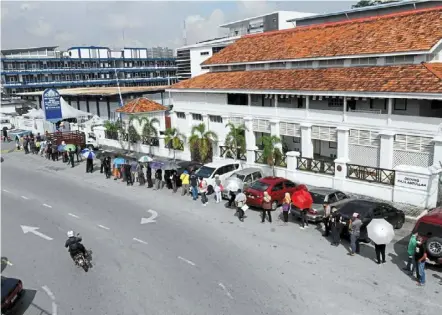  ?? — KK shaM/The star ?? Seeking approval: People queuing outside the south Klang police station to apply for a travel permit.