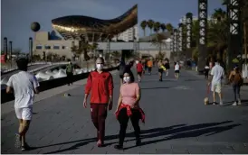  ?? FOTO: EMILIO MORENATTI/TT-AP ?? En spatsertur i solen på strandprom­enaden – det kunde Barcelonas befolkning avnjuta efter veckor av isolering.