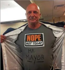  ?? KATHLEEN CAREY – DIGITAL FIRST MEDIA ?? Chester Water Authority worker Joe Stafford of Upper Chichester shows off his shirt, making his stance on any possible sale crystal clear, at a recent board meeting at Neumann University.