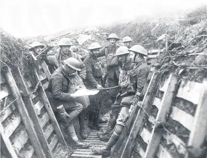  ??  ?? Soldiers listening to the news being read out as they wait in their trench World War One. 1918. Photograph Mirrorpix
