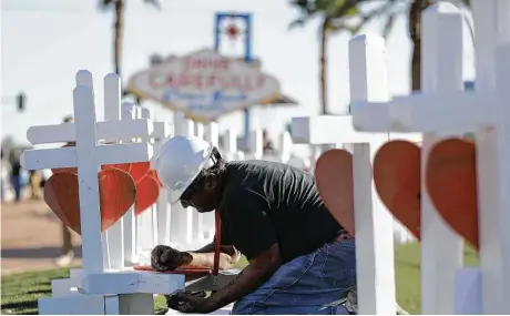  ?? Gregory Bull / AP ?? Greg Zanis escribe el nombre de una de las víctimas de la masacre del recital de hace un par de semanas en Las Vegas, Nevada.