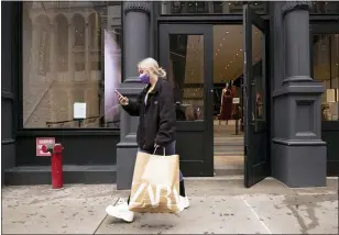  ?? MARK LENNIHAN — THE ASSOCIATED PRESS ?? A customer walks out of a Zara store last month in New York. U.S. consumer confidence rose sharply for a second straight month in April, hitting the highest level in more than a year as consumer sentiment was boosted by a more rapid rollout of the vaccines and another round of support payments.