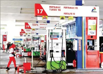  ?? SETO WARDHANA/THE JAKARTA POST ?? An attendant walks across a gas station belonging to state-owned energy holding company Pertamina in Kuningan, South Jakarta.