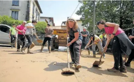  ?? ?? Mujeres y hombres de todas las edades retiran barro de una calle en Bera.