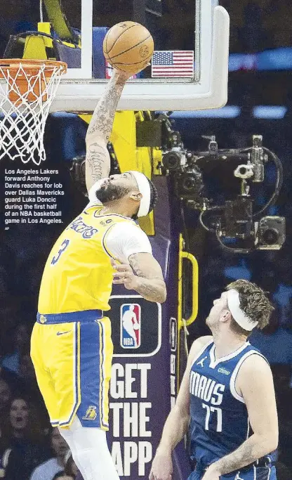  ?? AP ?? Los Angeles Lakers forward Anthony Davis reaches for lob over Dallas Mavericks guard Luka Doncic during the first half of an NBA basketball game in Los Angeles.