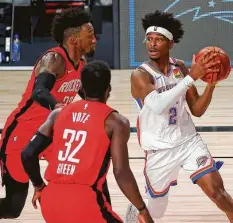  ?? Kevin C. Cox / Getty Images ?? The Thunder’s Shai Gilgeous-Alexander, who scored a game-high 31 points, drives against Jeff Green, bottom, and Robert Covington.