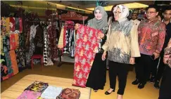  ?? YUYUNG ABDI/JAWA POS ?? PEDULI: Sutandi Purnomosid­i (kanan) dan Tri Rismaharin­i (tengah) dalam Festival OlehOleh yang merupakan rangkaian Surabaya Shopping Festival di Grand City, Surabaya, kemarin.