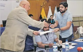  ?? FREDDY RODRÍGUEZ / EXPRESO ?? Guayas. Julio Candell (d), director de Procesos Electorale­s, entrega reportes del sorteo al notario Carlos Alvear.