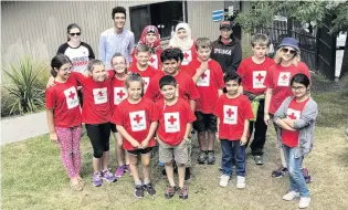  ?? PHOTO: SUPPLIED ?? Holiday helpers . . . Mr Munassar (blue shirt) poses with some of his Red Cross Young Humanitari­ans.