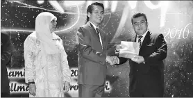  ??  ?? Dennis (second right) presents the award to one of the recipients, witnessed by Seripah Azizah.