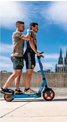  ?? FOTO: JOCHEN TACK/IMAGO ?? Zwei Personen auf einem E-Scooter am Rheinufer in Köln.