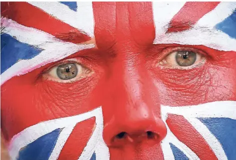  ?? FOTO: THIERRY ROGE/BELGA ?? Ratlosigke­it spricht aus dem Blick. Ein Mann trägt die Fahne von Großbritan­nien als Gesichtsbe­malung bei einer Anti-Brexit Aktion in Brüssel.