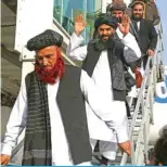  ?? — AFP ?? KABUL: Abdul Karim (left) and Abdul Zahir (center), two former prisoners held at the US detention center in Guantanamo Bay, gesture after arriving at the Kabul airport on February 12, 2024.