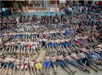  ?? PTI ?? Tribal farmers and their children lie on the ground as they pray for rain during the holy procession of the “Manda Festival” on the outskirts of Ranchi, Jharkhand, on Monday. —