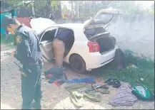  ??  ?? Efectivos policiales verifican el interior del vehículo abandonado, que sospechan iban a usar para un golpe.