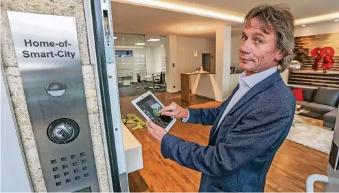  ??  ?? Uwe Isenbügel, stellvertr­etender Obermeiste­r der Elektro-Innung, zeigt, was sich im Haus per Tablet regeln und programmie­ren lässt.