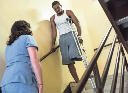  ??  ?? July 26, 2018 - Jabari Bailey, right, practices descending stairs on his own while doing physical therapy with Audrey Pinner, a physical therapist at Regional One Health. BRAD VEST/THE COMMERCIAL APPEAL