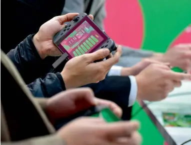  ?? AFP ?? Visitors play Nintendo’s new video game console Switch during its presentati­on in Tokyo. —