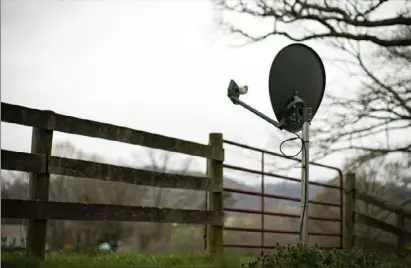  ?? Al Drago/Bloomberg ?? An internet satellite dish sits in the yard of a house in Madison, Va., on March 31. The new Affordable Connectivi­ty Program from the government will bring home internet service to qualifying U.S. households at no out-of-pocket cost.