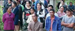  ?? ZHANG ZHENG / FOR CHINA DAILY ?? Left: Relatives of the missing wait for news at the constructi­on site.