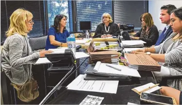  ?? LANNIS WATERS / THE PALM BEACH POST ?? Elizabeth “Betsy” Savitt (left) answers questions from senior attorney for the Department of Elder Affairs, Michael McKeon (right center) at a hearing in front of Judge Mary Li Creasy (center) on Wednesday.