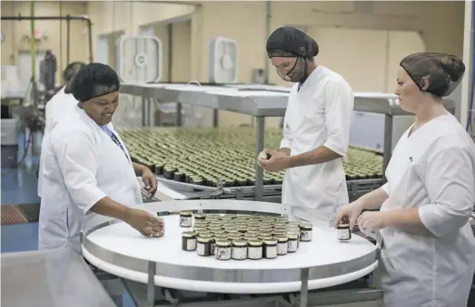  ?? PHOTOS BY LUKE CHRISTOPHE­R ?? At the former Aileen plant — where hundreds once worked — Missy Phillips, Brandon Deal and Michelle Pullen are among the Virginia Chutney Co.’s 10 employees. Cofounder Clare Turner, right, runs the business with her husband Nevill and son Oliver, left.