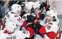  ?? MICHAEL DWYER/THE ASSOCIATED PRESS ?? Ottawa Senators teammates surround left wing Clarke MacArthur, centre, after he scored a goal against the Boston Bruins in overtime on Sunday in Boston.