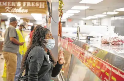  ?? Steve Gonzales / Staff photograph­er ?? Tattiana Hubbred, shopping Monday at Farmer’s Fresh Meat, said she supports customers being required to wear masks.