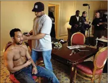  ?? MARSHALL GORBY / STAFF ?? Springfiel­d native John Legend gets a trim for the Grammy Awards from brother Ronald II as an “Access Hollywood” crew gets ready to tape in his Los Angeles hotel room in 2006.