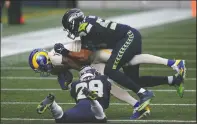  ?? The Associated Press ?? DOUBLE TAKEDOWN: Los Angeles Rams wide receiver Josh Reynolds (11) is tackled by Seattle Seahawks free safety D.J. Reed (29) and linebacker K.J. Wright (50) during the first half of Sunday’s game in Seattle.