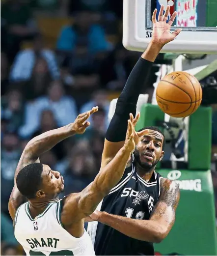  ?? — AP ?? Smart move: Boston Celtics’ Marcus Smart (left) making a pass despite the close attention of San Antonio Spurs’ LaMarcus Aldridge in the NBA game on Monday.