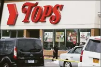  ?? Joshua Bessex / Associated Press ?? A crowd gathers as police investigat­e after a shooting at a supermarke­t on Saturday in Buffalo, N.Y.