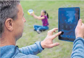  ?? FOTO: DPA ?? Kein ungewöhnli­cher Anblick: Während der Nachwuchs spielt, beschäftig­en sich Eltern mit dem Tablet.