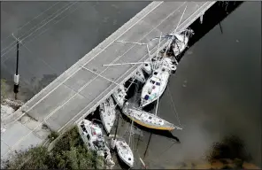  ?? AP/South Florida Sun-Sentinel/MIKE STOCKER ?? Boats are wedged under a bridge in Marathon, Fla., on Wednesday. Cleanup from Hurricane Irma will take weeks, but the recovery will take months, officials said.